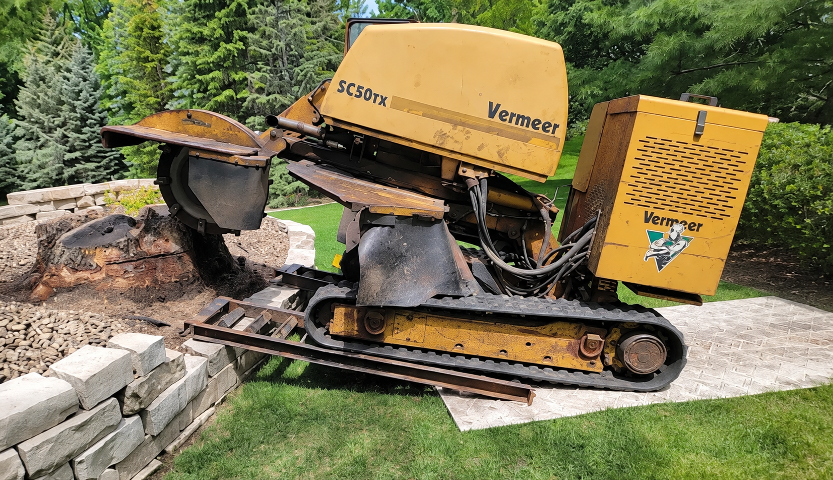 Vermeer stump grinder positioned beside a tree stump